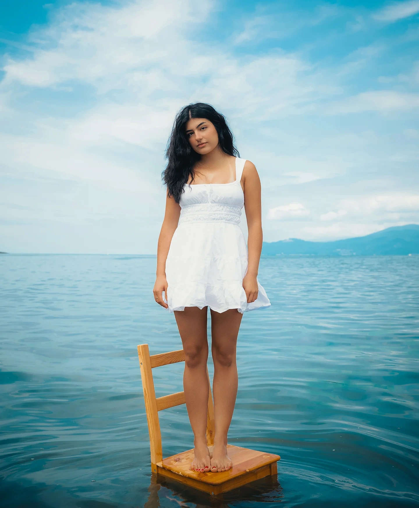 Tina editorial cover portrait in the ocean wearing a white dress